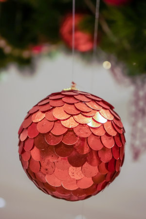 Red polished metal bauble decorated on Christmas tree. Spherical decoration are used to festoon artificial Xmas tree.の写真素材