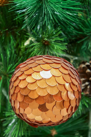 Gold polished metal bauble decorated on Christmas tree. Spherical decoration are used to festoon artificial Xmas tree.の写真素材
