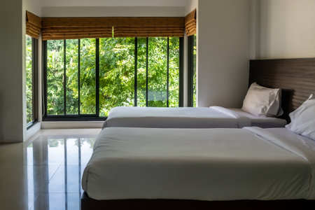 Modern master twin bedroom with garden view. The design of wide glass window to give scenic view of natural outdoor.の写真素材