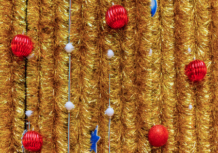 Christmas ornaments on a golden tinsel background. Lights, ball, star are used to festoon the celebration.の写真素材