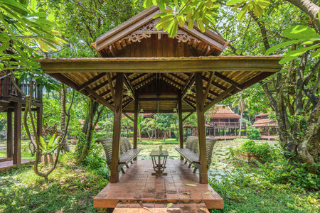 An ancient Thai-style pavilion in the garden. It has a long seating area for relaxing and is built entirely of wood and brick block.の写真素材