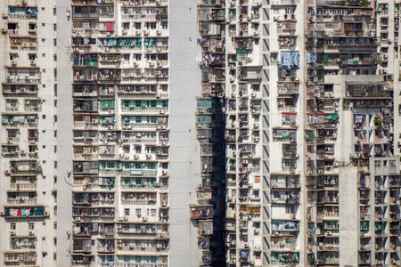 Densely Populated Residential Building Facade in Macau. A full frame, view of a colossal and densely packed residential building facade in Macau, showcasing windows and balconiesの写真素材