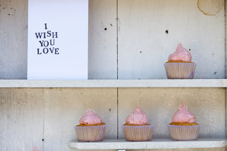 White vintage shelf with i wish you love card and strawberry cream cupcakeの写真素材