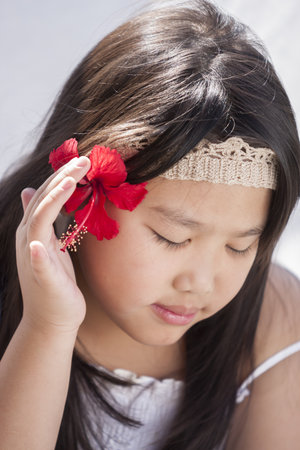 Cute little girl with hibiscus  flowerの写真素材