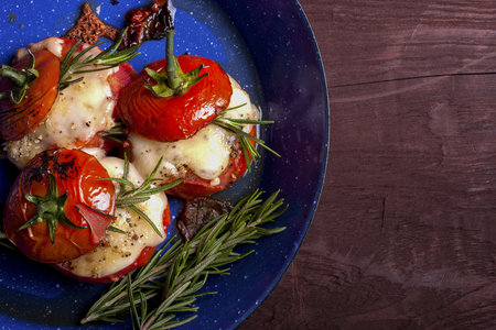 Oven roasted tomatoes stuffed with cheese in a blue panの写真素材