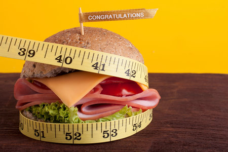Hamburger wrapped in a measuring tapeの写真素材