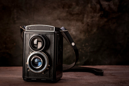 Old vintage viewfinder camera on wooden table.
