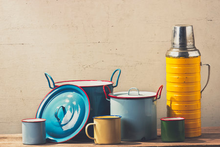 Old colorful enamel kitchenware on wooden table.(vintage mood)の写真素材