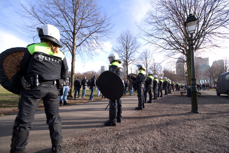 27 januari 1025 riot police officers watching in line protesters during a demonstration on the Malieveld in The Hague Hollandのeditorial素材