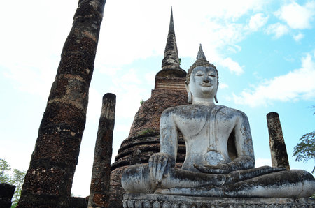 Buddha sitting in front of pagoda, background blue sky.の写真素材