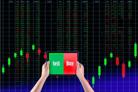 Holding tablet to show screen sell or buy isolated with background stock market graph run number chart, business investment and risk  exchange background.の写真素材