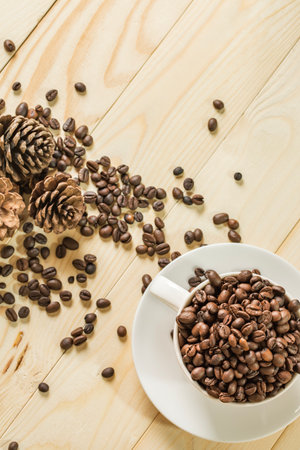 the top view, close up coffee beans in cup with  wooden background, selective focus and effect filter.の写真素材