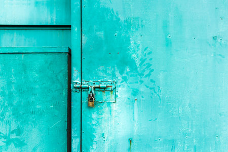 close up on green door with the key locked, abstract background with vintage filter. to show the old texture on metallic.の写真素材