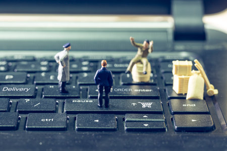 Miniature figurine, businessman is standing on shopping cart button and waiting order from customer shopping internet of thing, and messenger are looking for new delivery. Cyber Business concept.の写真素材