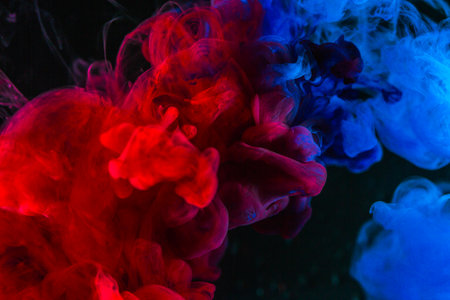 Abstract background, Splashing smoke color texture in the air. Smoke fragments isolated on dark background, lowkey lighting.の写真素材