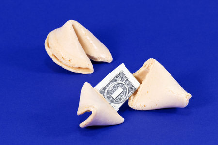 A fortune cookie with a dollar bill insideの写真素材
