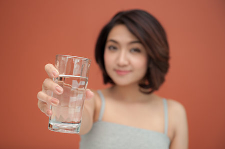 healthy young woman holding with glass of drinking waterの写真素材