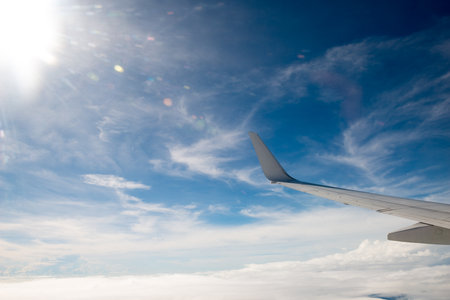 airplane wing with beautiful sky above the clouds
