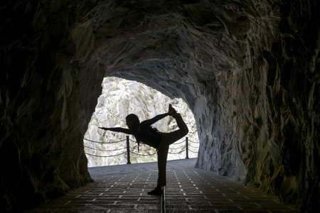 silhouette of woman Yoga pose in caveの写真素材