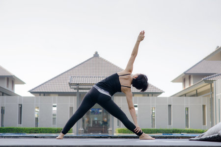 Asian women  practice  Yoga with swimming pool backgroundの写真素材