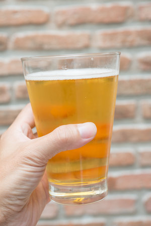 glass of craft beer with hand holdingの写真素材