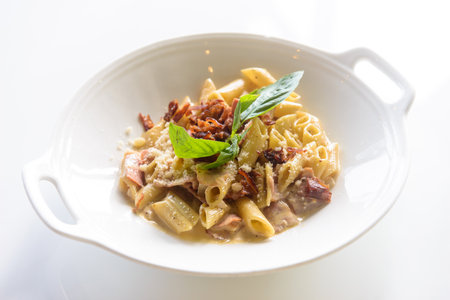 Penne pasta with crispy bacon cheese and cream sauceの写真素材