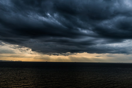 Strom clouds with Rays of sunlight and dark ocean