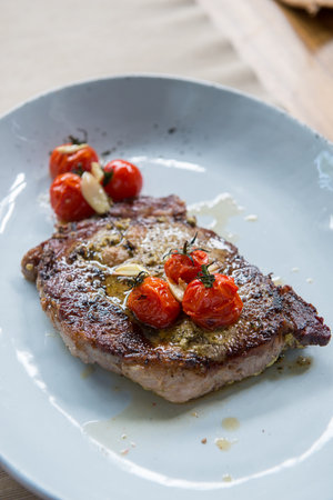 Grilled beef steak with tomatoes and garlicの写真素材
