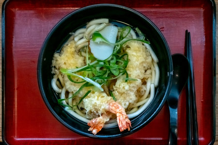 Shrimp Tempura Udon: A delightful combination of crispy shrimp tempura and thick, chewy udon noodles, served in a flavorful and comforting broth.の写真素材