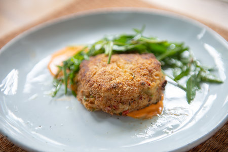 Indulge in a flavorful dinner with this crab cake recipe. Succulent crab cakes are paired perfectly with a fresh and peppery rocket salad, creating a delightful combination of tastes and textures.の写真素材