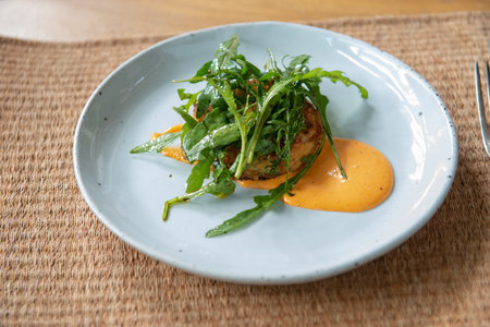 Indulge in a flavorful dinner with this crab cake recipe. Succulent crab cakes are paired perfectly with a fresh and peppery rocket salad, creating a delightful combination of tastes and textures.の写真素材