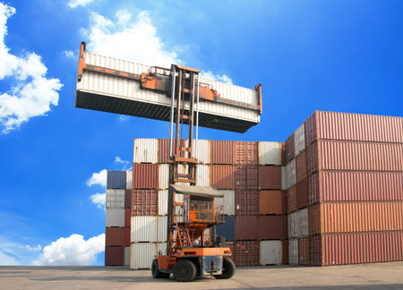 Crane lifting up container in railroad yard
