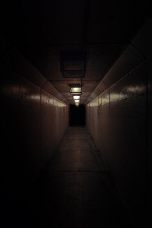 Dimly lit concrete hallway or tunnel. No people. Very dark and scary.の写真素材