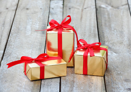 gift box wrap gold paper with red ribbonの写真素材
