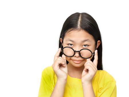 Asian young girl with glasses looks questioninglyの写真素材