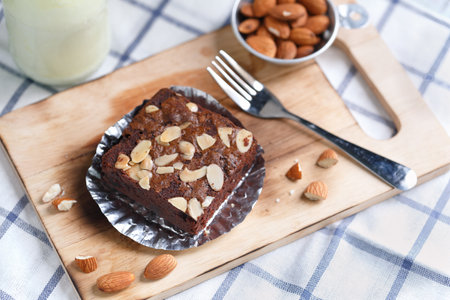 Chocolate brownie almond cake on wood plateの写真素材