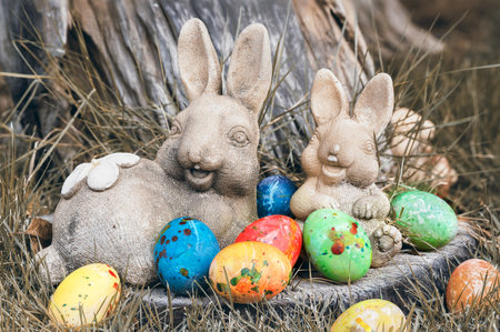 bunny statue (my garden) in sepia tone with colorful eggs easter