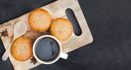 Snack banana muffins with black coffee on a black  wood backgroundの写真素材