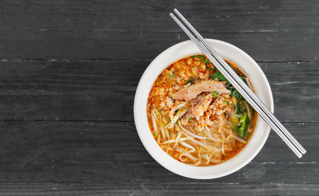 spicy pork noodle isolated on black wood backgroundの写真素材