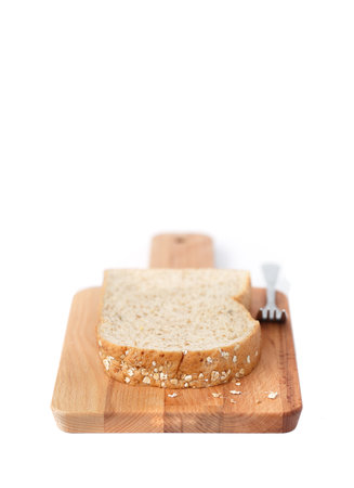 Wholemeal bread on a chopping board isolated on white background