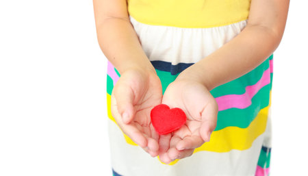 Little hands hold a red heartの写真素材