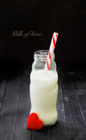 Bottle milk with red heart on dark wood backgroundの写真素材