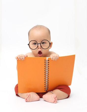 Cute baby wear eyeglasses and reading big bookの写真素材