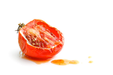 Rotten tomato with juice isolated on white backgroundの写真素材