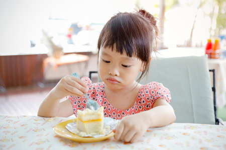 Bangkok, Thailand - July 5, 2016: cute little girl eating cakeのeditorial素材