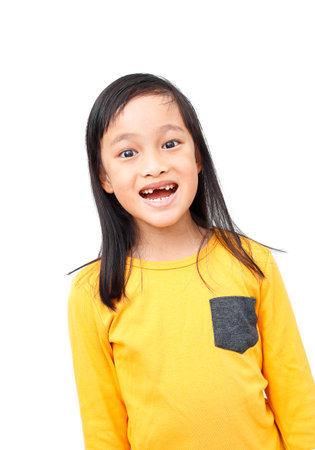 Little girl show Broken milk tooth with smile. Isolated on white background