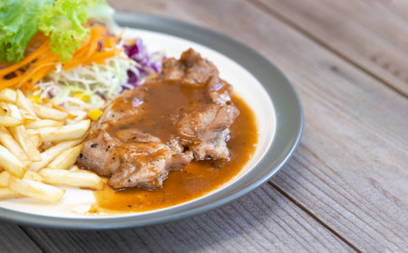 Pork steak with french fries on a white dishの写真素材