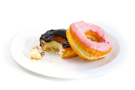 The donut was bitten on a white plate. Isolated on white backgroundの写真素材