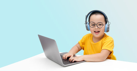 Little boy wearing headphones using laptop, happy learning,  listening audio course, e-learning...