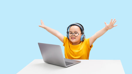 Little boy wearing headphones using laptop, happy learning,  listening audio course, e-learning education conceptの写真素材